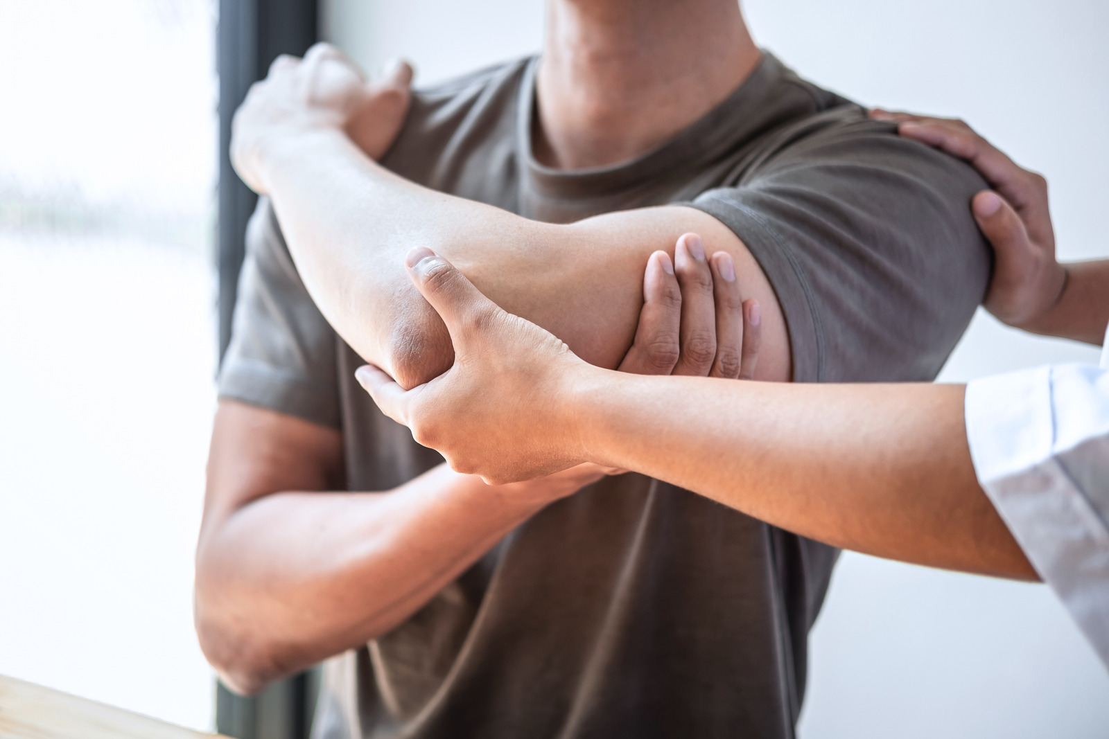 Female Physiotherapist at Manly West working examining treating injured arm of